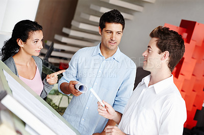 Buy stock photo Three talented architects discussing how they improve upon their blueprints