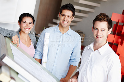 Buy stock photo Portrait of three talented architects working on their design blueprints together
