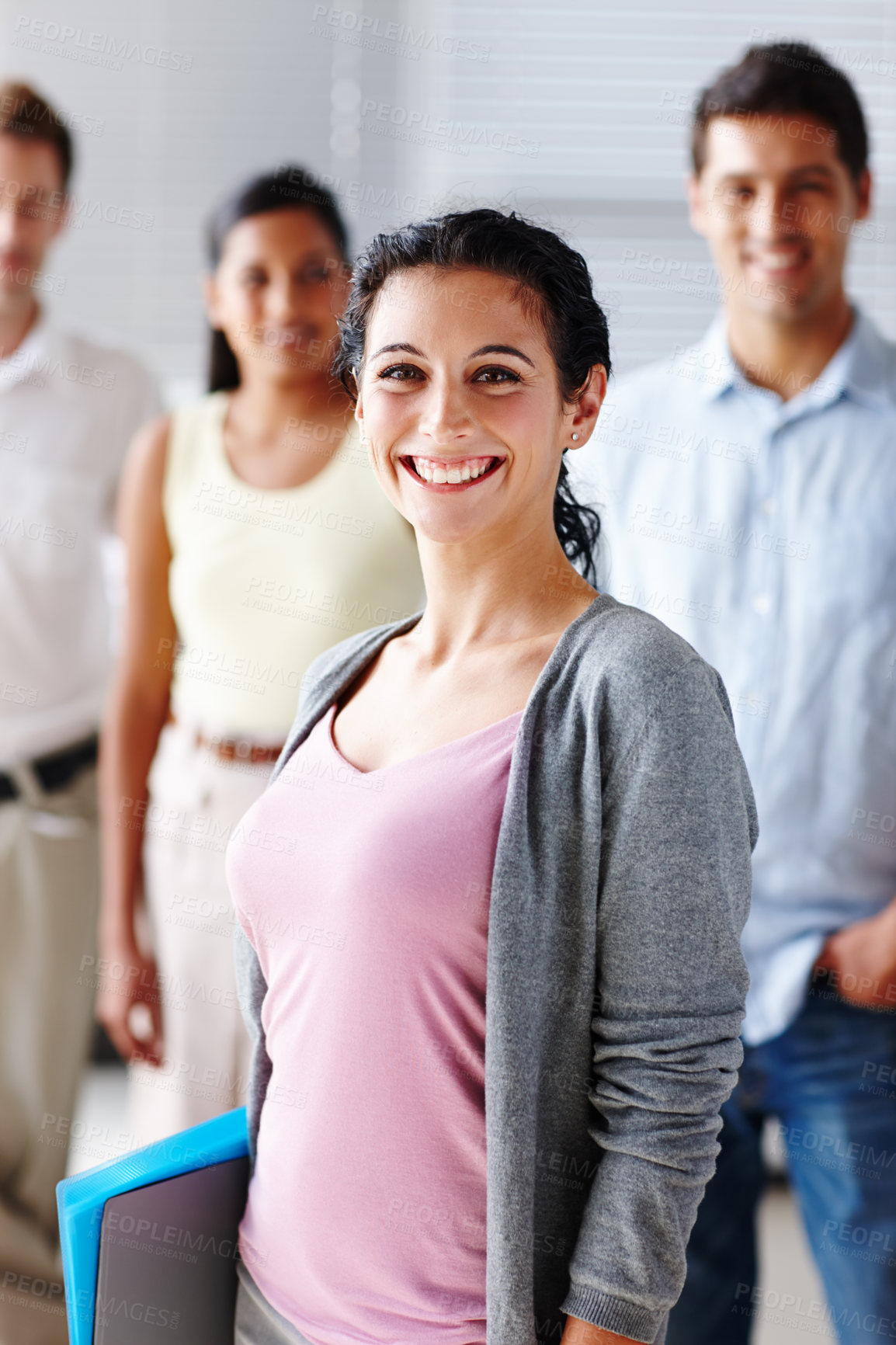 Buy stock photo Portrait of a beautiful young businesswoman smiling at you with her team blurred in the background