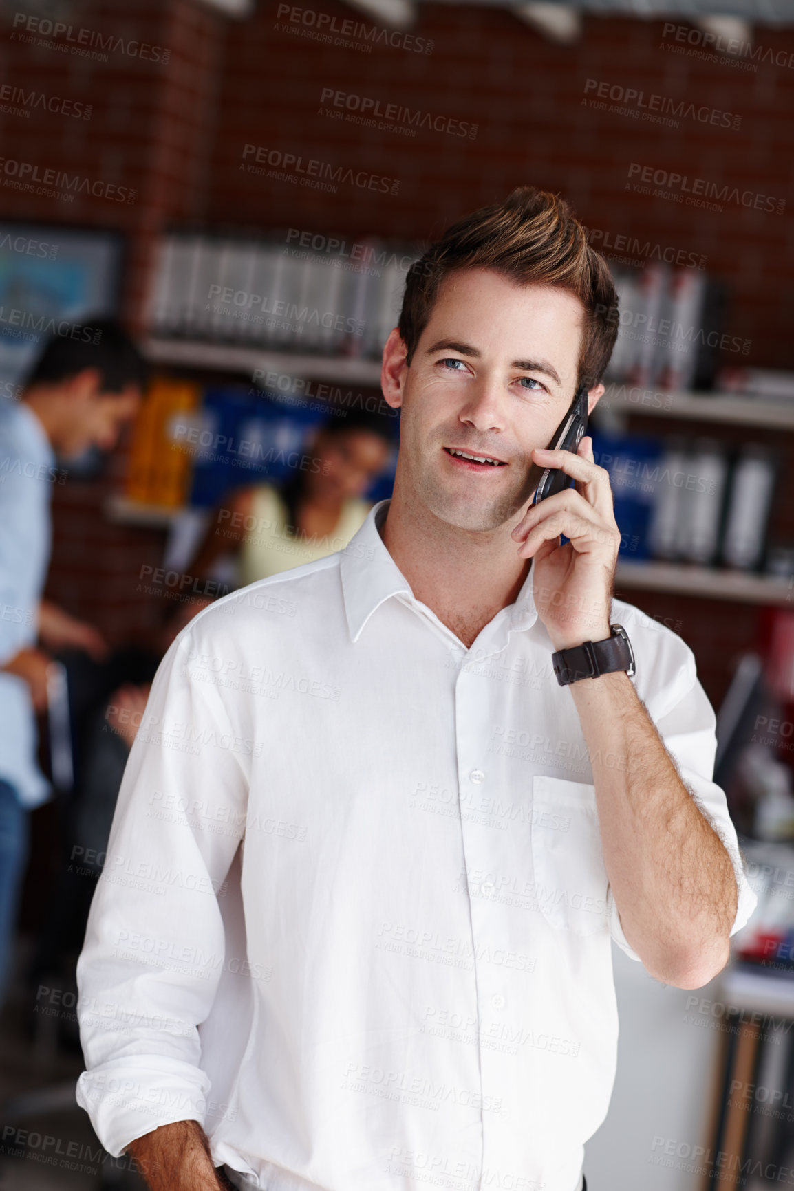 Buy stock photo A handsome young businessman taking a call from a client