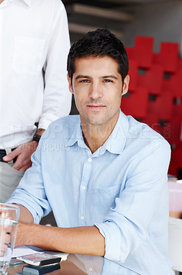 Buy stock photo Portrait of a confident young businessman sitting at the boardroom table