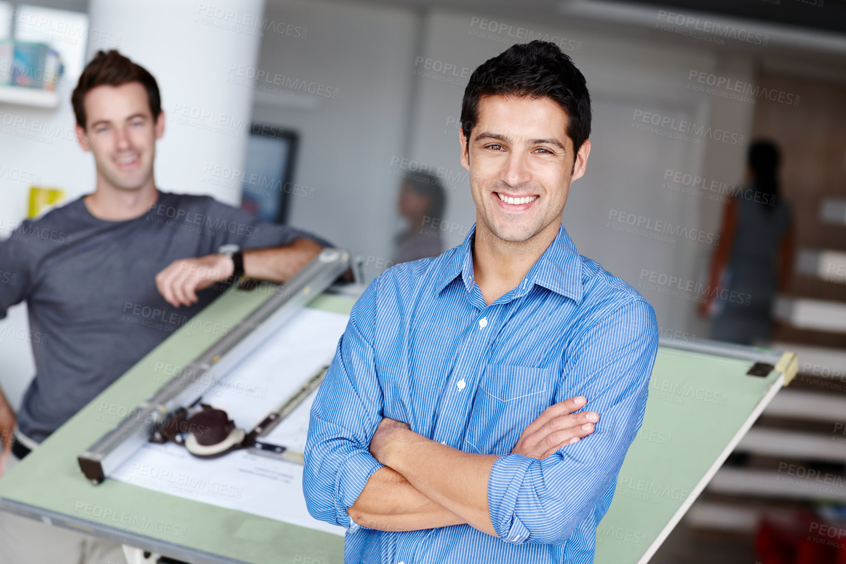 Buy stock photo A handsome young architect standing next to his blueprints with a colleague