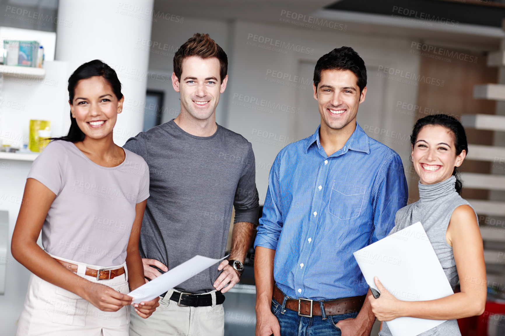 Buy stock photo A young team of business people smiling at you confidently in the office