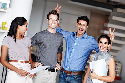 Buy stock photo A comedic businessman pulling bunny ears on two of his colleagues in the office