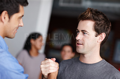 Buy stock photo Two businessmen motivating each other by clasping hands and gazing into one another's eyes