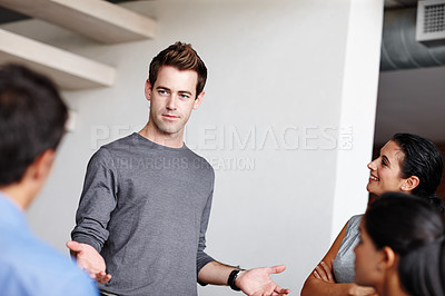 Buy stock photo A young business creative presenting to his colleagues in the boardroom