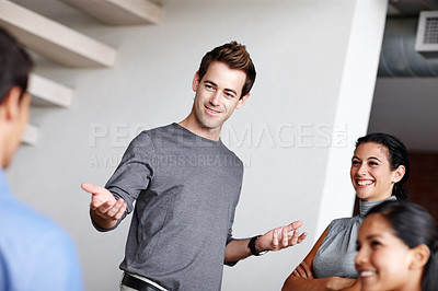 Buy stock photo A young business creative presenting to his colleagues in the boardroom