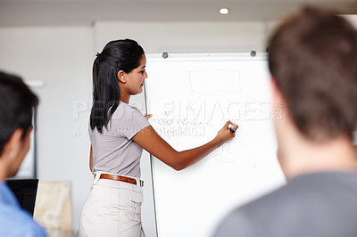 Buy stock photo A young businesswoman facilitating a budget meeting in the boardroom