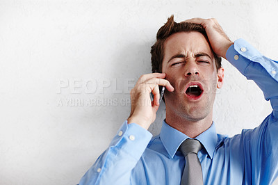 Buy stock photo A young businessman taking a devastating call alongside copyspace