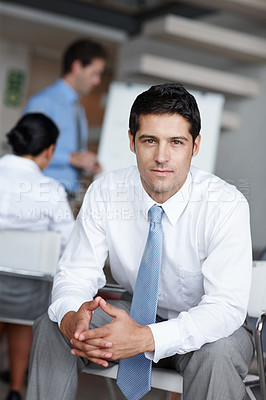 Buy stock photo A young business executive looking at you confidently with clasped hands