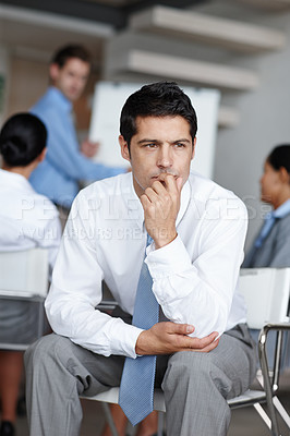 Buy stock photo A young executive lost in though at the office