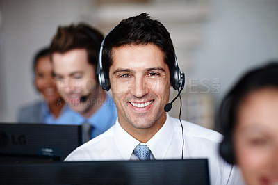 Buy stock photo A handsome young call center agent enjoying his job tremendously