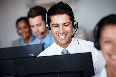 Buy stock photo A handsome young call center agent enjoying his job tremendously