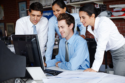 Buy stock photo An enterprising business team working on a project together on a computer