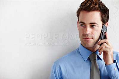 Buy stock photo A young businessman looking towards copyspace while taking a disappointing call