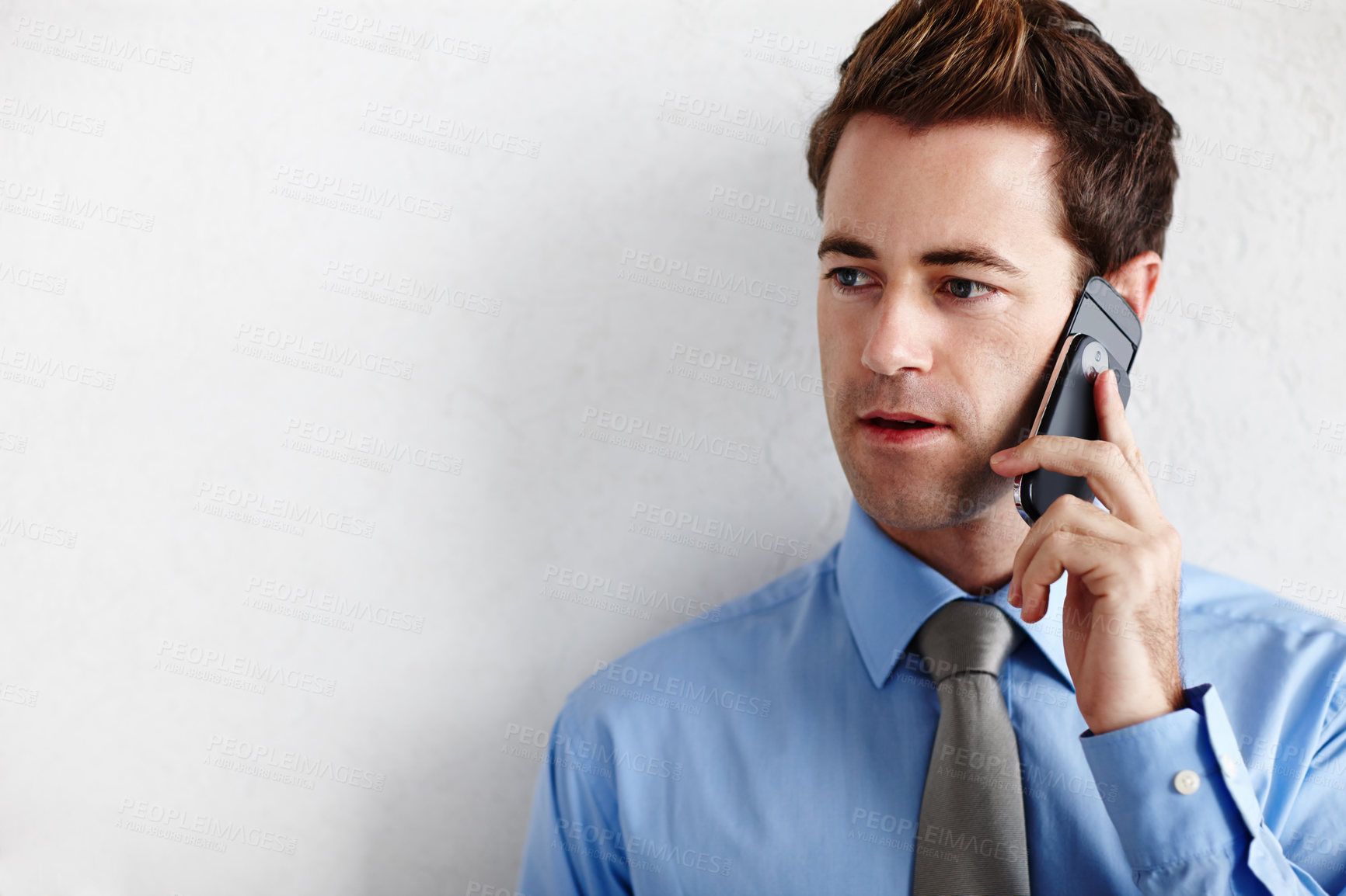 Buy stock photo A young businessman looking towards copyspace while taking a disappointing call