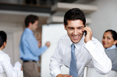 Buy stock photo A young executive taking a call during a business presentation