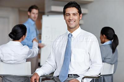 Buy stock photo A handsome executive smiling at you confidently during a business presentation