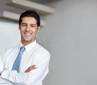 Buy stock photo A handsome young businessman crossing his arms and looking at you with a wide smile