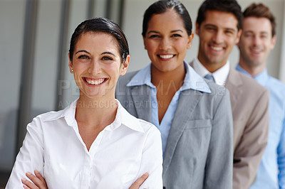 Buy stock photo A confident young businesswoman crossing her arms with her team in a line behind her