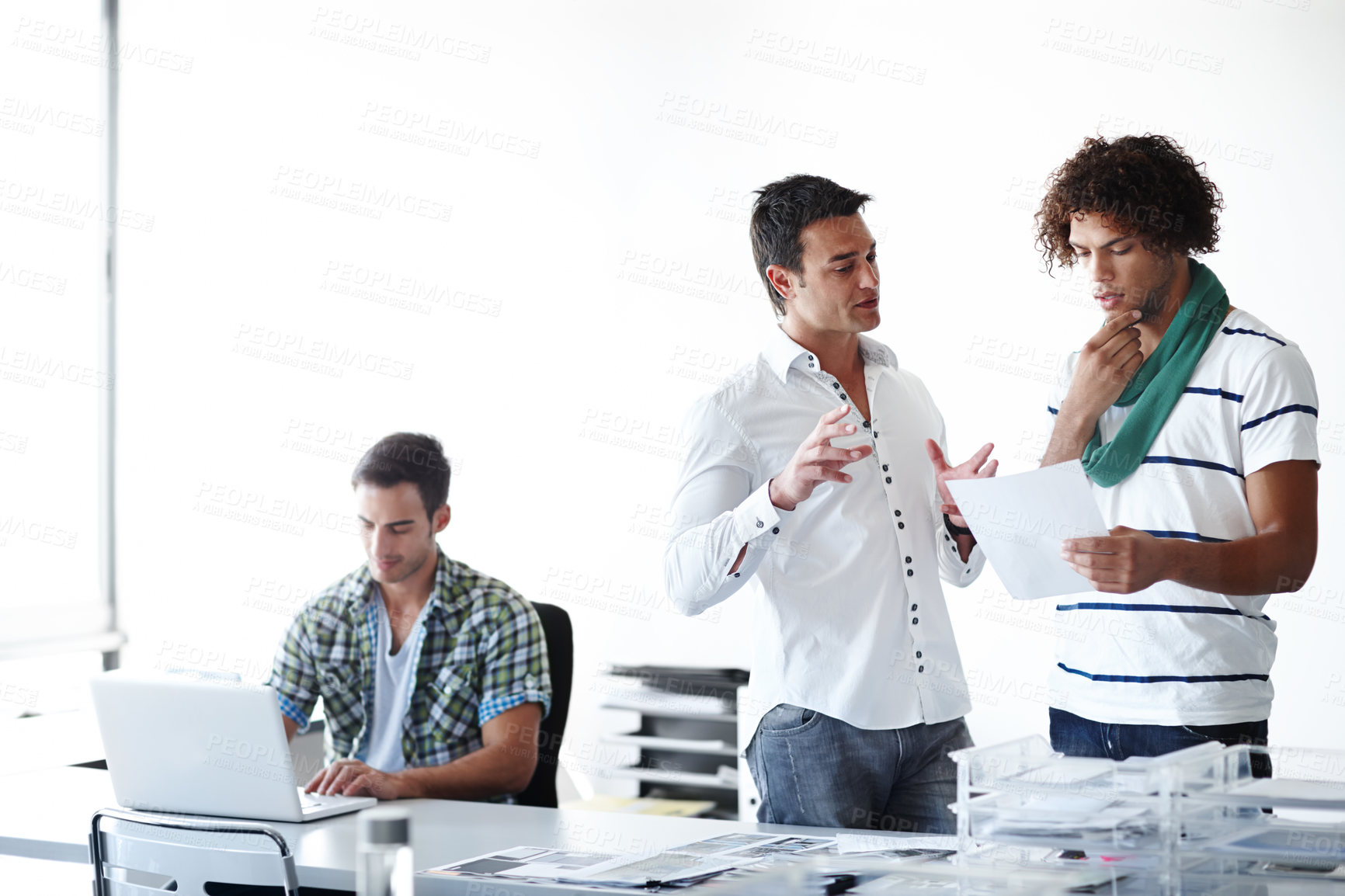 Buy stock photo Three male coworkers working in the office together