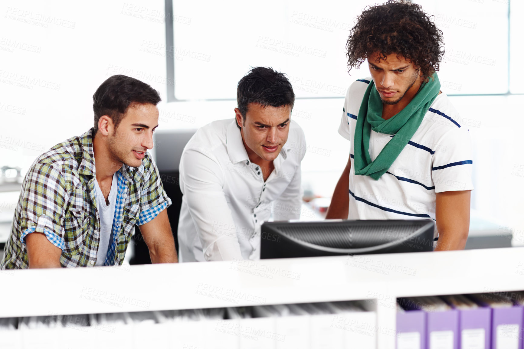 Buy stock photo Three male colleagues working in the office together