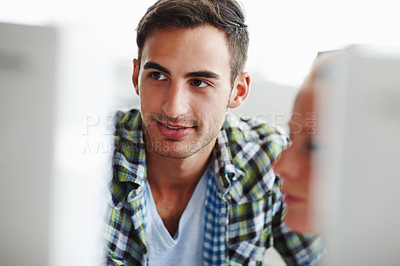 Buy stock photo Two colleagues working on a computer together