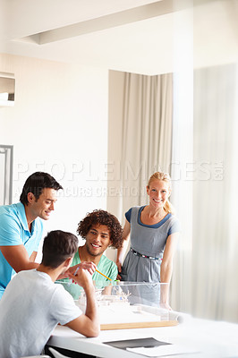Buy stock photo A group of architects discussing a building model during a meeting