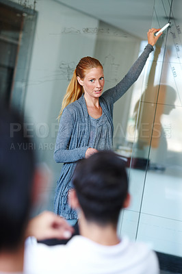 Buy stock photo Attractive casual businesswoman giving a presentation using a glass window for demonstration
