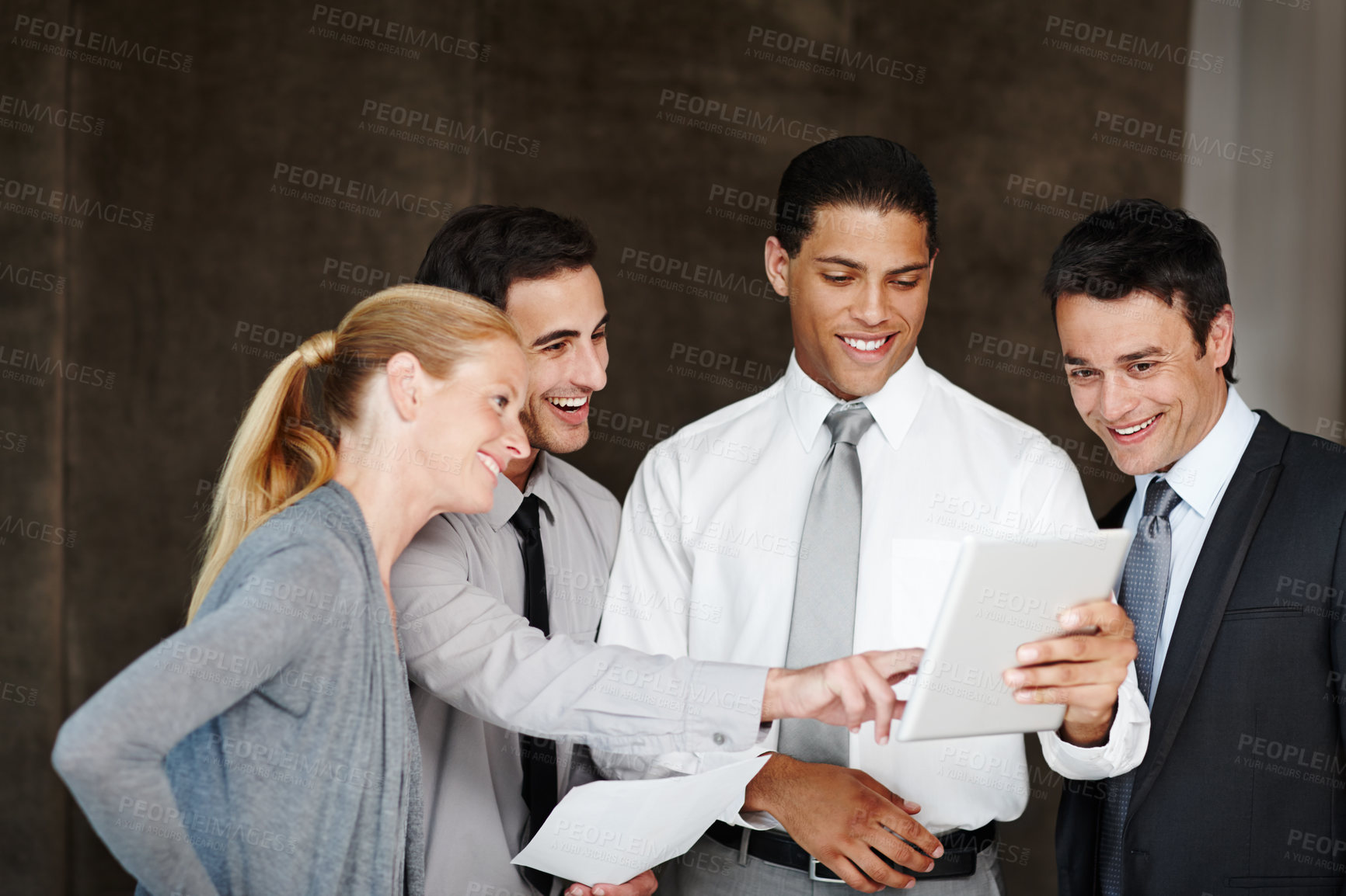Buy stock photo Multi-ethnic group of businesspeople talking while using a digital tablet