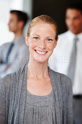Buy stock photo Attractive businesswoman standing with her coworkers in the background