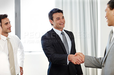 Buy stock photo A positive businessman shaking hands with a coworker during a meeting