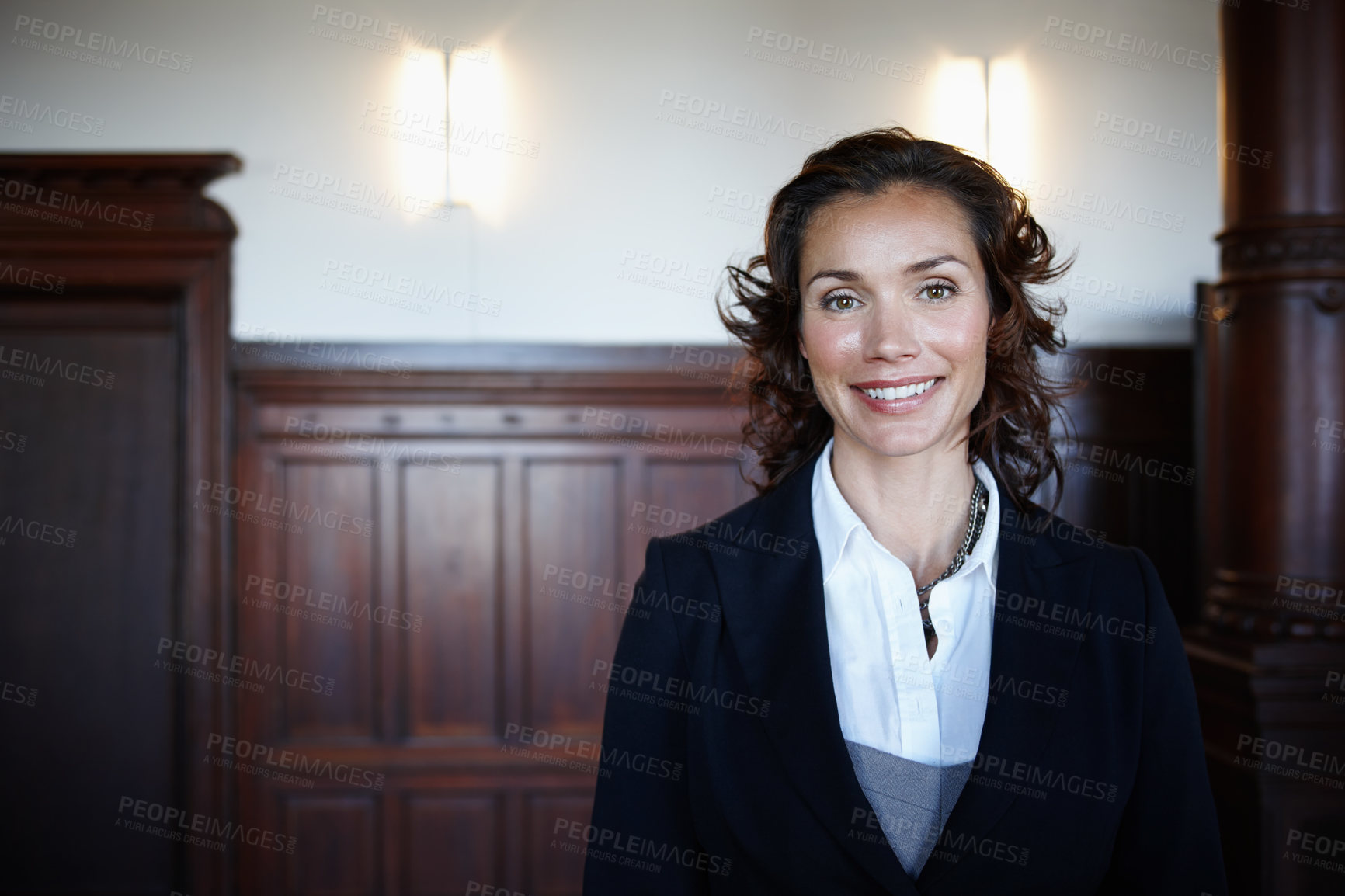 Buy stock photo Cropped shot of an attractive mature female lawyer standing in a courtroom and smiling