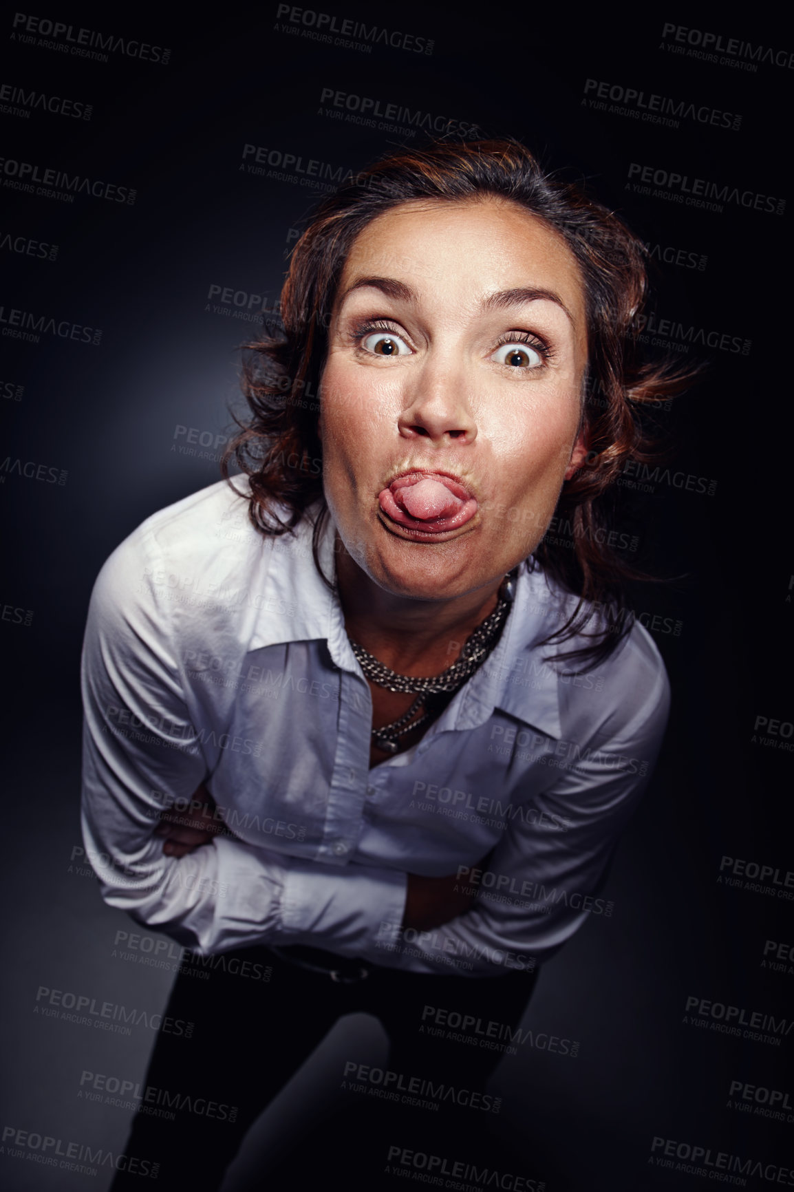 Buy stock photo Mocking, tongue out and face of woman with gesture isolated on dark background in studio. Rude, mean and portrait of person gesturing for comedy, naughty expression and backchat communication