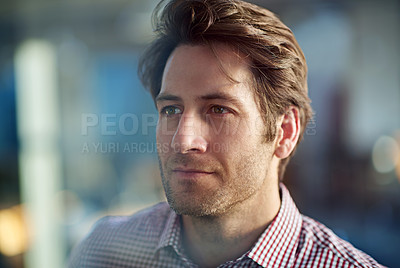Buy stock photo Defocused shot of a handsome young businessman in his workplace