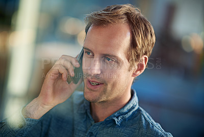 Buy stock photo Shot of a handsome businessman talking on his mobile phone in the workplace