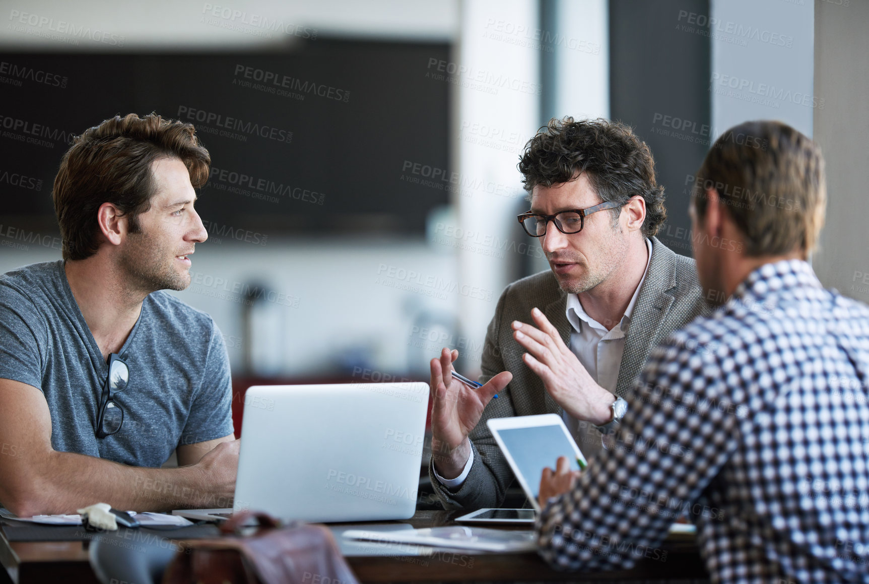 Buy stock photo Cropped shot of three businessman discussing work in the office