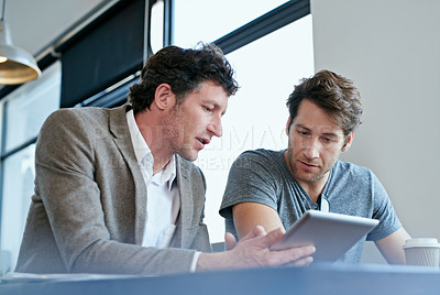 Buy stock photo Cropped shot of two businessmen working on a digital tablet