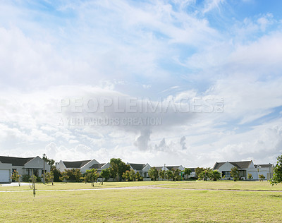 Buy stock photo Residential area, sky and grass with secure park for walking, sports or playing summer games. Real estate, clouds and field for development, property management and housing with outdoor lawn