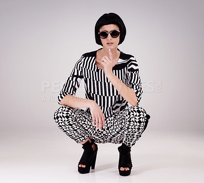 Buy stock photo Fashion, portrait of woman in studio for edgy, vintage or retro clothing with gray background. Serious, confident and female model kneeling for aesthetic, designer sunglasses and stylish outfit