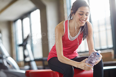 Buy stock photo Woman, water bottle and music in gym for workout, fitness and exercise for wellness. Training, energy and female person listening to playlist on earphones, aerobics and pilates with beverage 