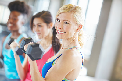 Buy stock photo Happy woman, face and workout in gym with dumbbell for muscle, strong body and training class. Female athlete, exercise and weightlifting in wellness club with fitness, healthy friends and energy