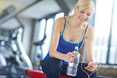 Buy stock photo Woman, headphones and water with smartphone in gym for workout research, training blog and hydration. Female person, relax and smile with technology for fitness progress, exercise break and audio