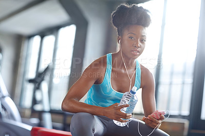 Buy stock photo Phone, headphones and portrait of black woman in gym with water, fitness app or online subscription. Health, wellness and girl checking music playlist on smartphone with bottle, break and sports club