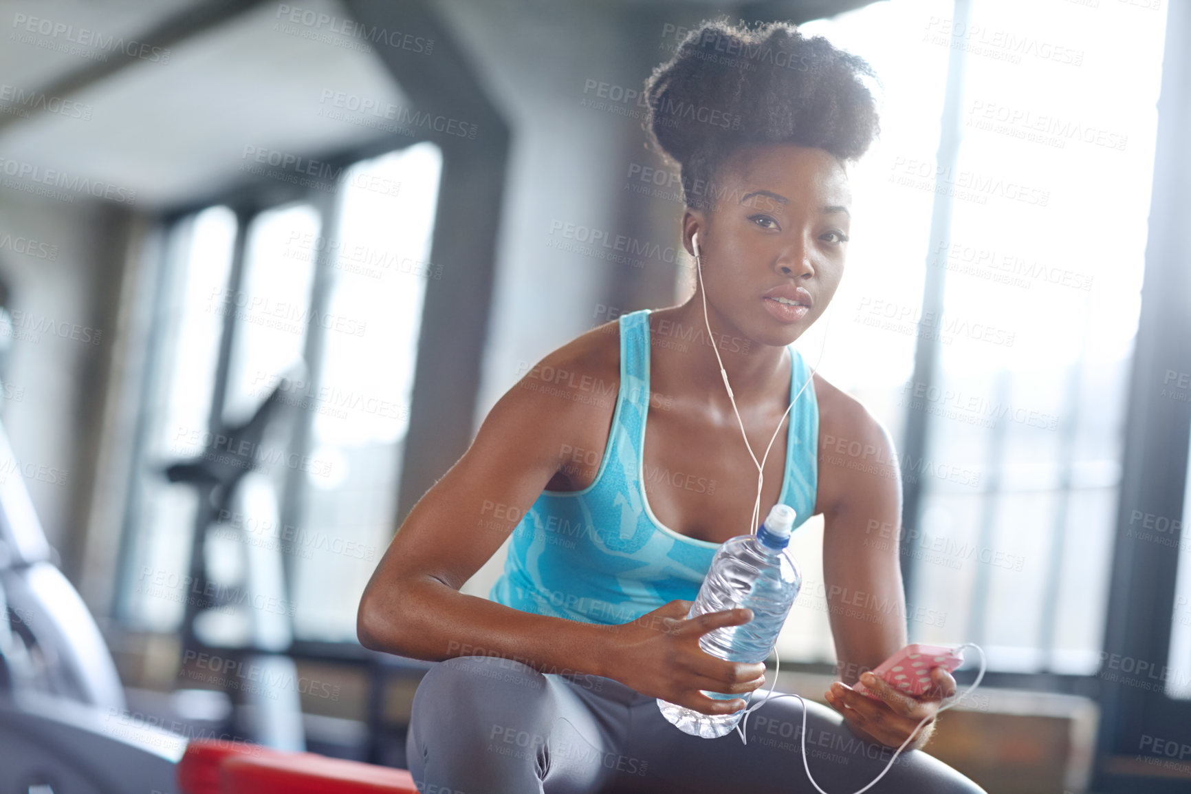 Buy stock photo Phone, headphones and portrait of black woman in gym with water, fitness app or online subscription. Health, wellness and girl checking music playlist on smartphone with bottle, break and sports club