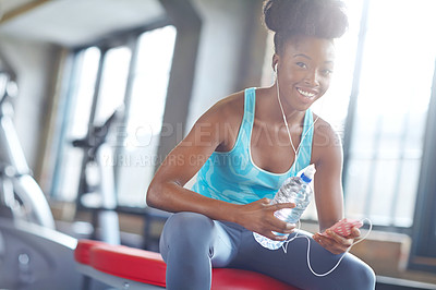 Buy stock photo Smartphone, headphones and portrait of black woman in gym with water, fitness app or online subscription. Health, wellness and girl checking music playlist on phone with bottle, break and sports club