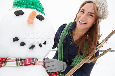 Buy stock photo Portrait of an attractive young woman building a snowman