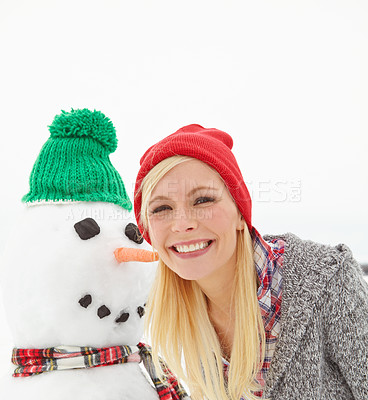 Buy stock photo Cropped shot of a beautiful young woman standing beside a snowman