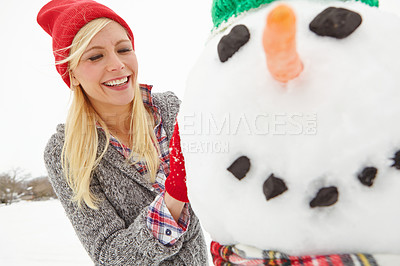Buy stock photo Winter, snow and woman building a snowman outdoors during Christmas in England with happiness. Smile, festive season and xmas snow man being built by a happy female outdoors in cold weather 