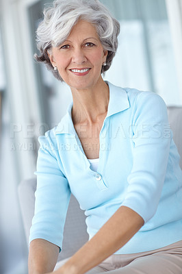 Buy stock photo Portrait of happy senior woman sitting at home on the sofa. Mature woman smiling on a couch at her house. Attractive older lady with good teeth and a full head of thick grey hair relaxing in a lounge